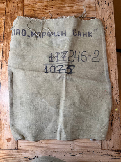 Vintage burlap bag with text on a wooden surface