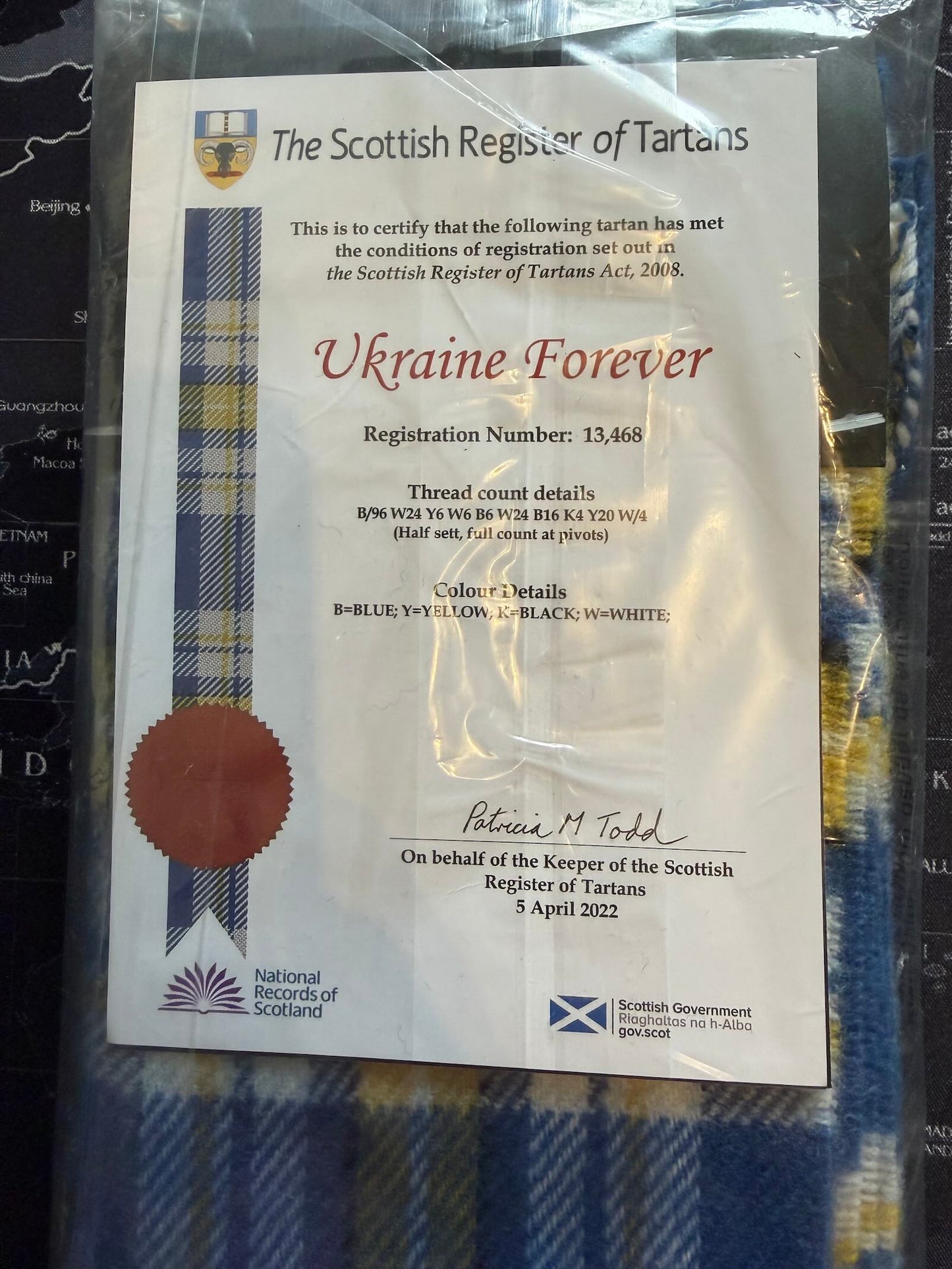 Scottish Register of Tartans certificate for 'Ukraine Forever' design on a tartan fabric background.