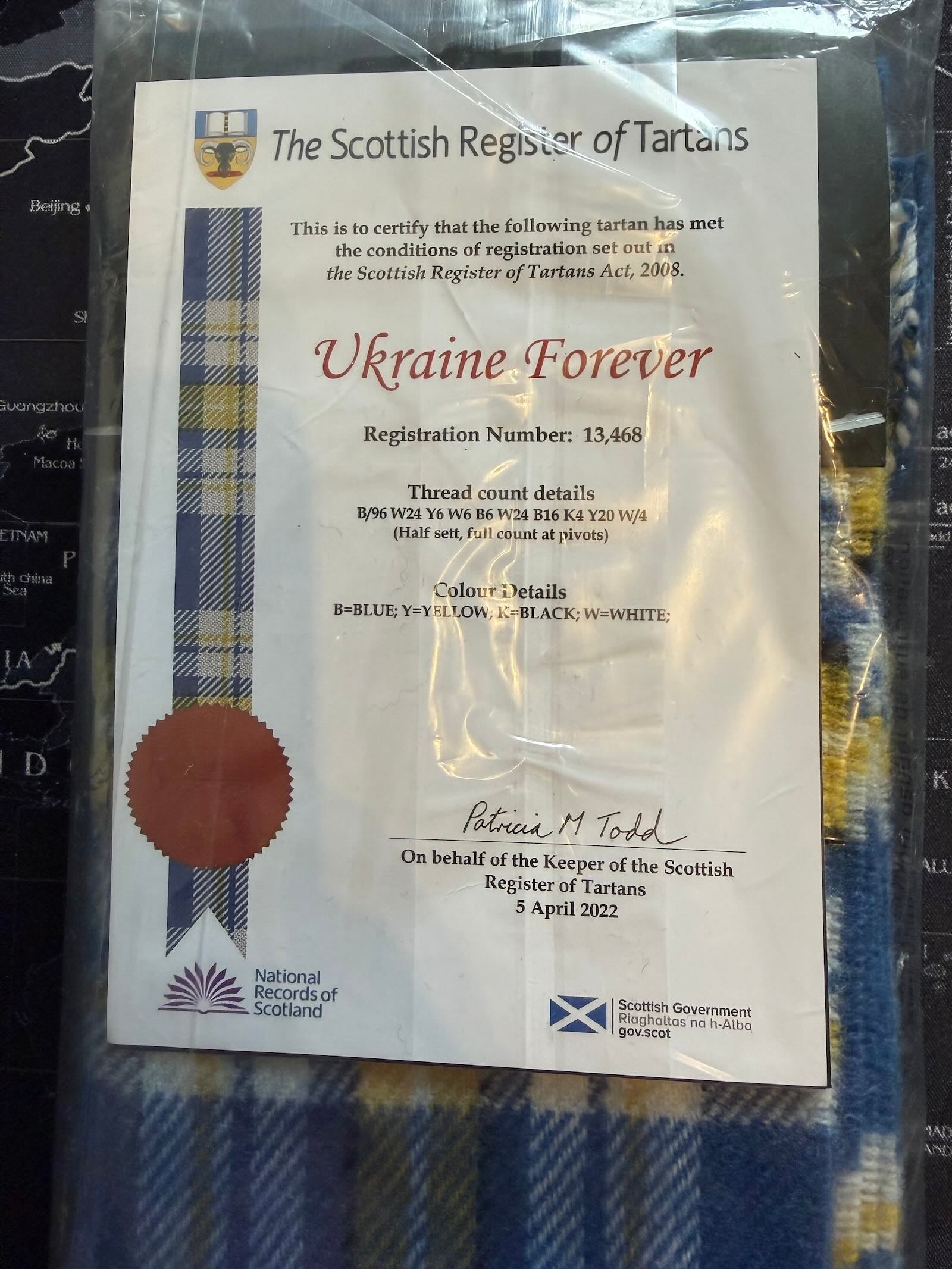 Scottish Register of Tartans certificate for 'Ukraine Forever' design on a tartan fabric background.