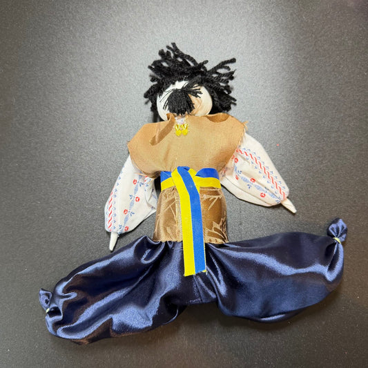 Traditional doll with a blue skirt and brown top on a gray background
