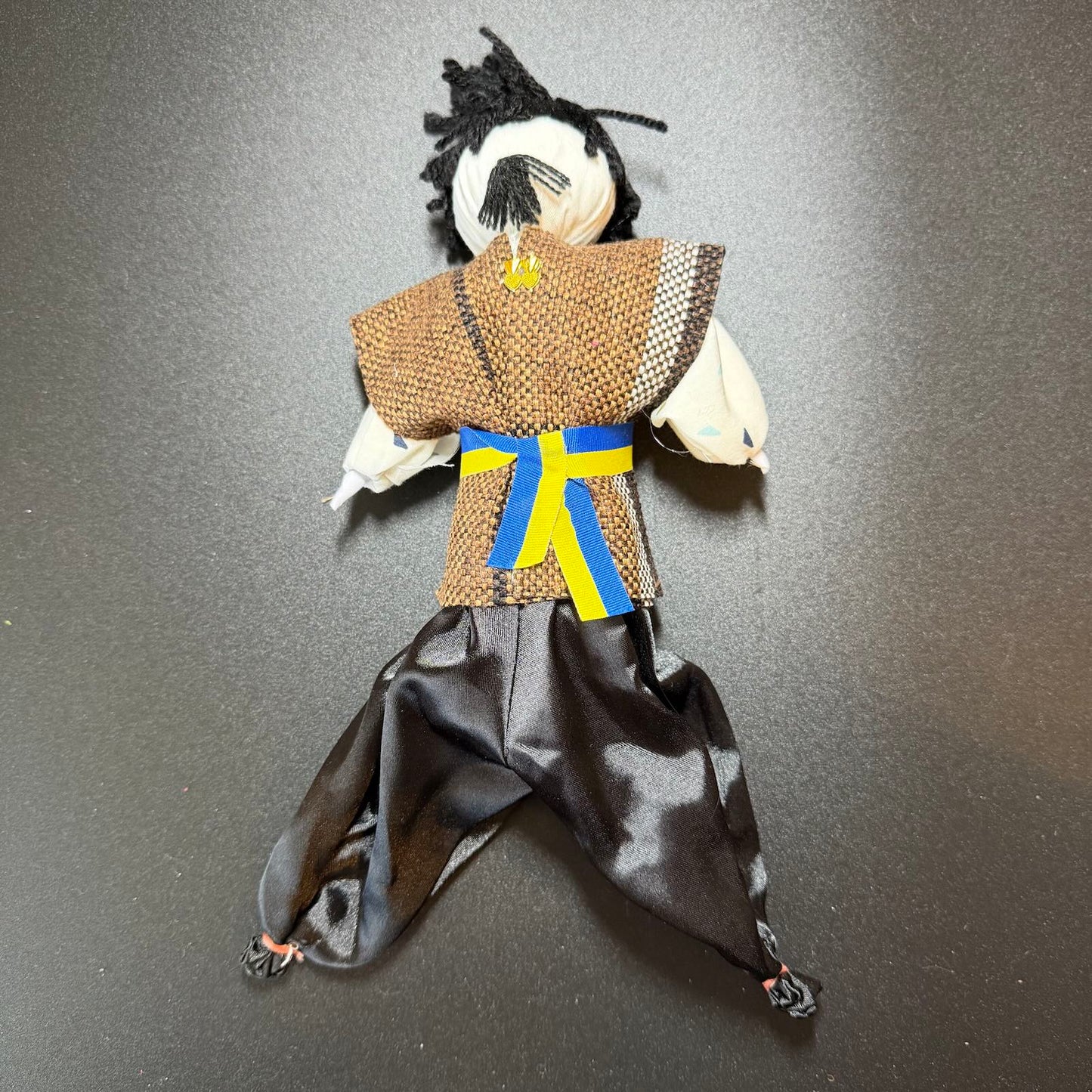 Handmade doll in traditional attire on a dark background