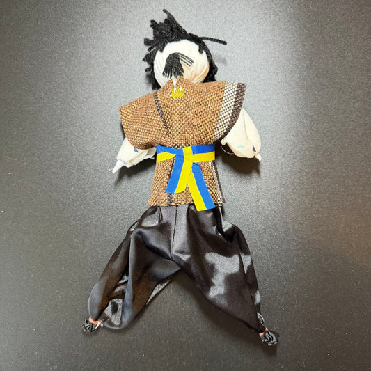 Handmade doll in traditional attire on a dark background