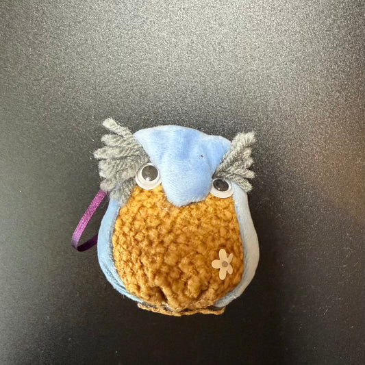 Small crocheted owl toy on a metallic surface