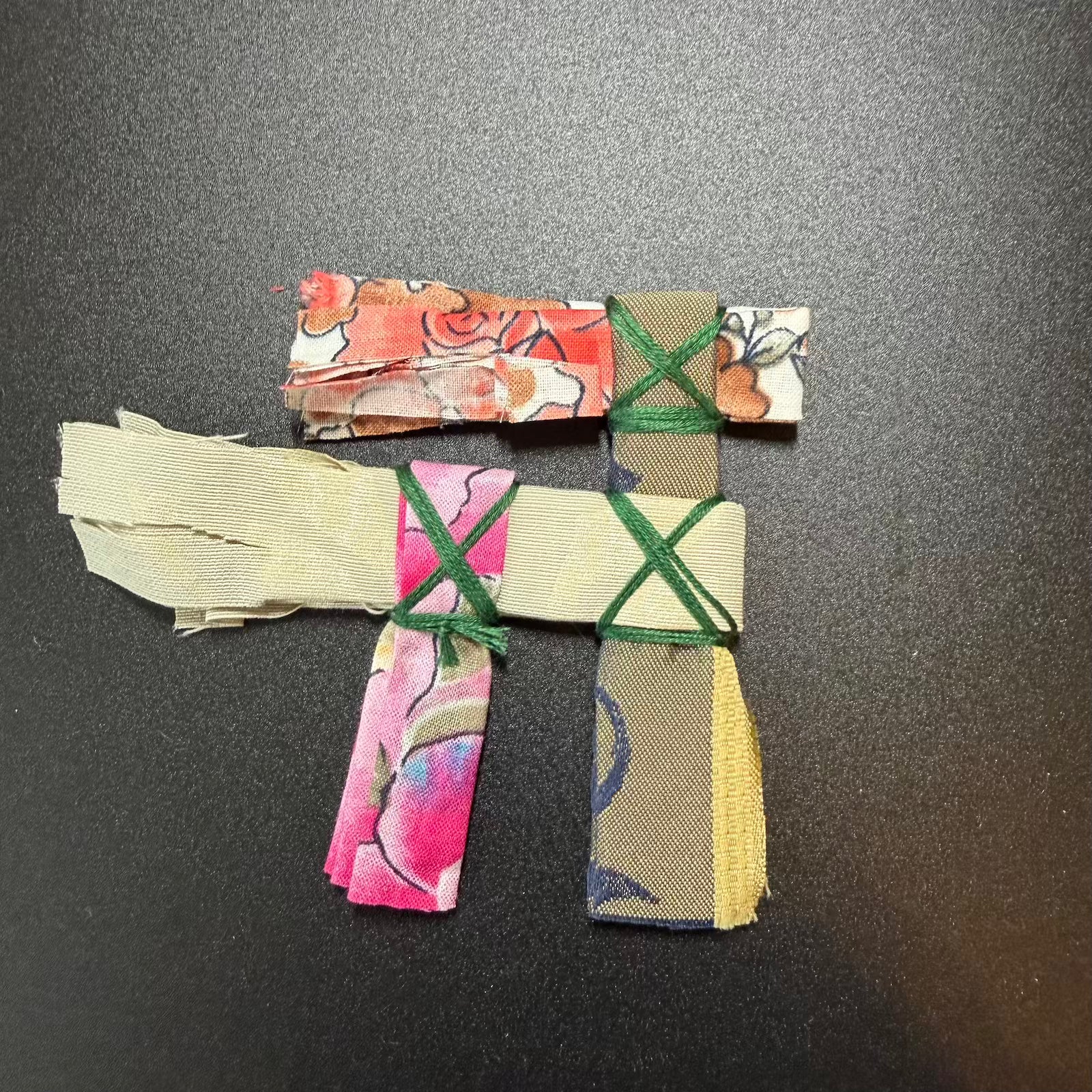 Colorful fabric strips tied together on a dark surface