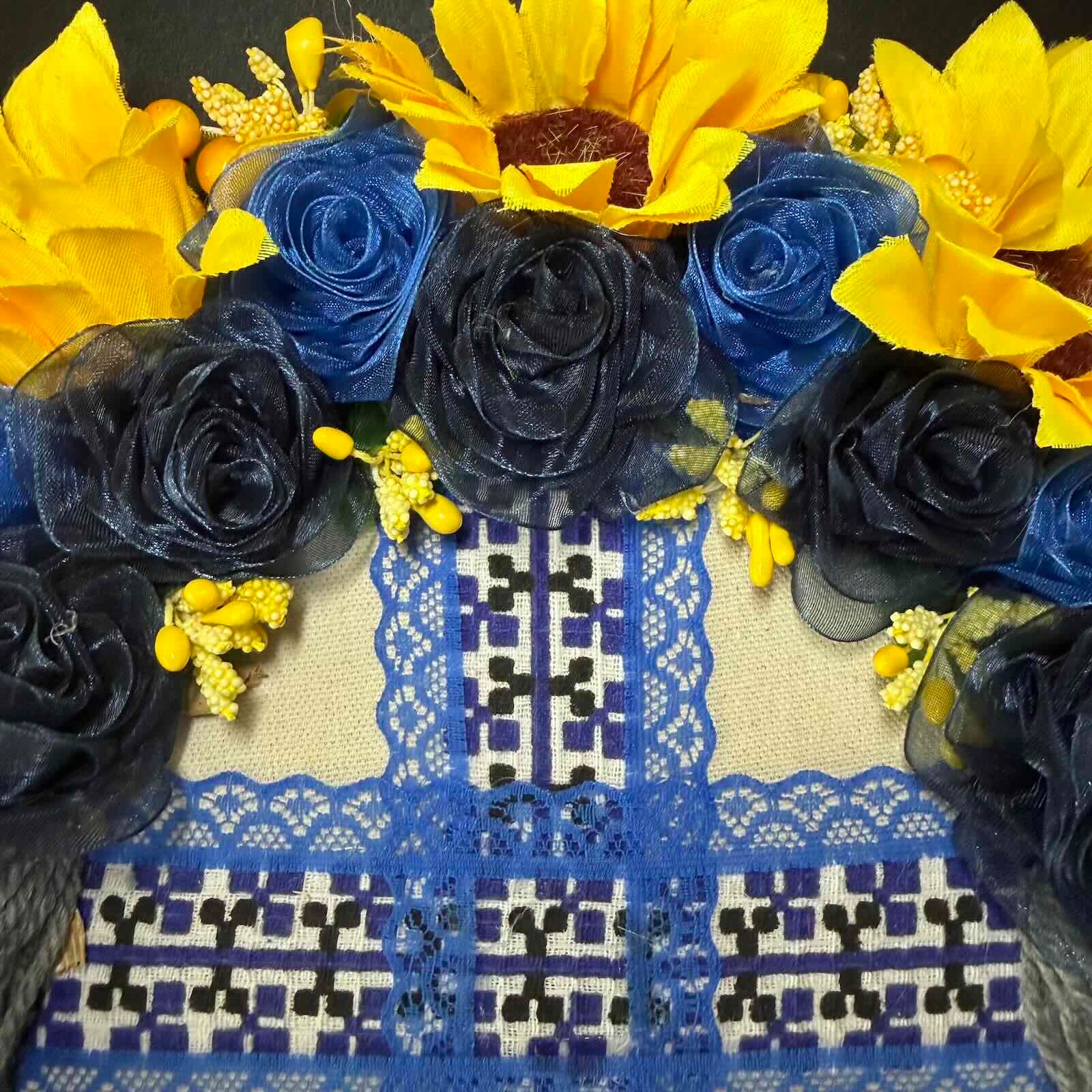Decorative arrangement of yellow sunflowers and blue roses on a patterned fabric background