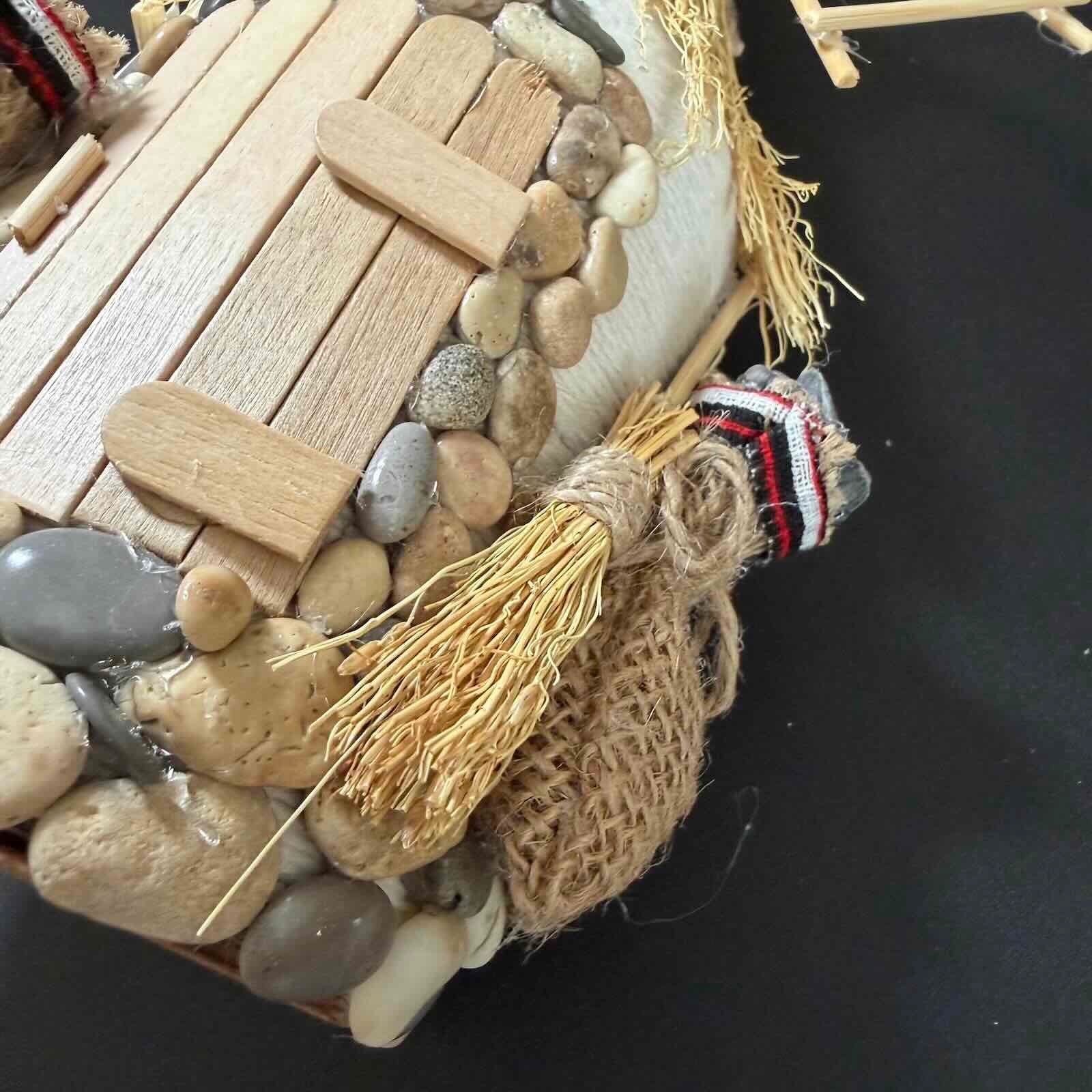 Decorative item with stones, wood, and a tassel on a dark background
