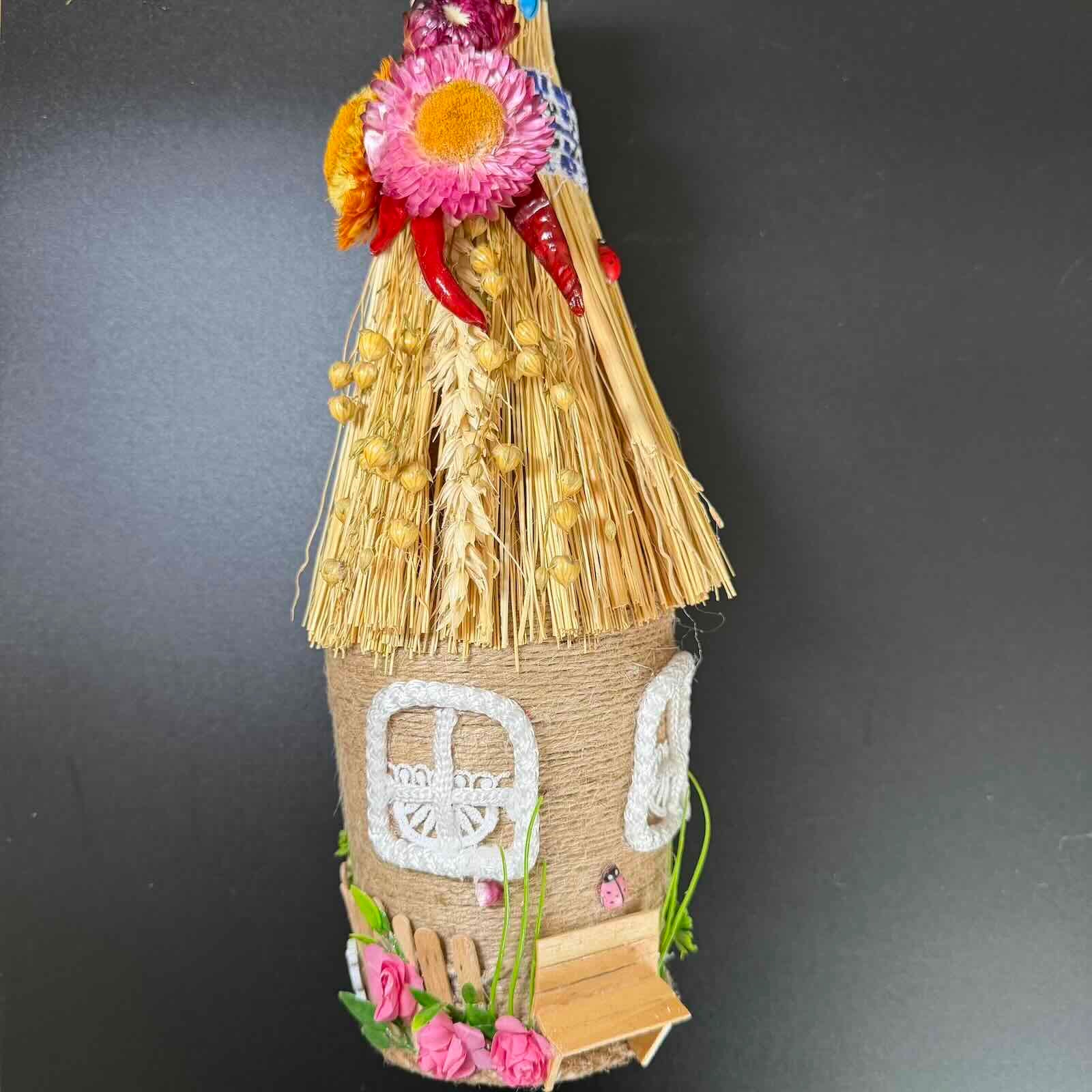 Decorative straw house with flowers on a dark background