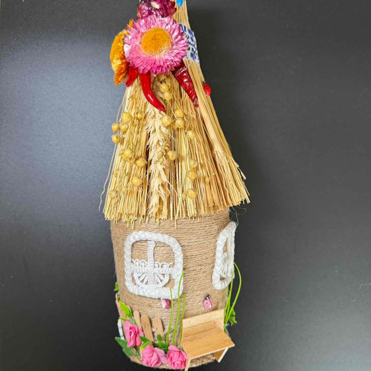 Decorative straw house with flowers on a dark background