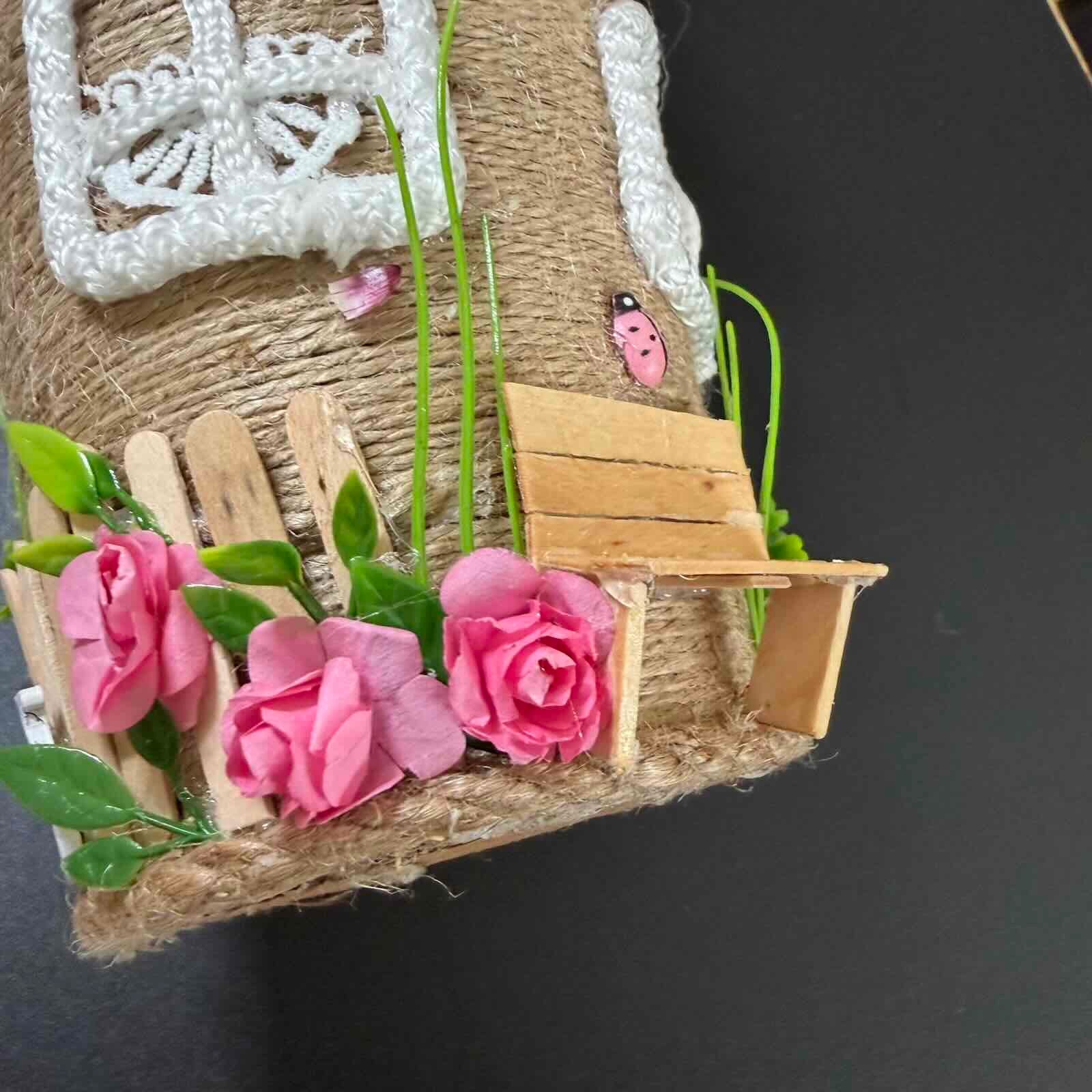 Small wooden bench with pink flowers and greenery on a textured surface