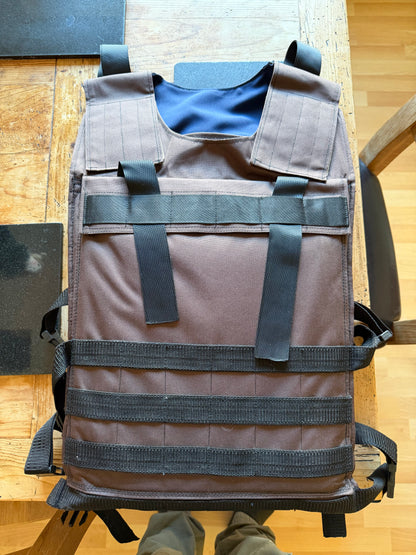 Front view of the handmade brown Ukrainian body-armour carrier, with black webbing, shoulder fastenings and adjustable waist straps.