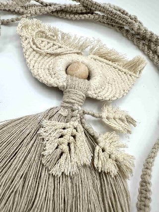 Macrame wall hanging with tassels on a white background