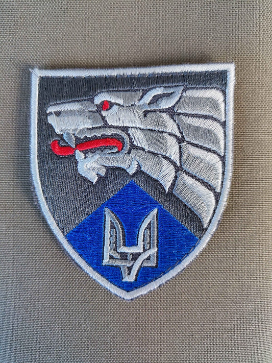 Fabric patch depicting a Wolves head in silver with a red tongue. Underneath is a Ukrainian Trident symbol
