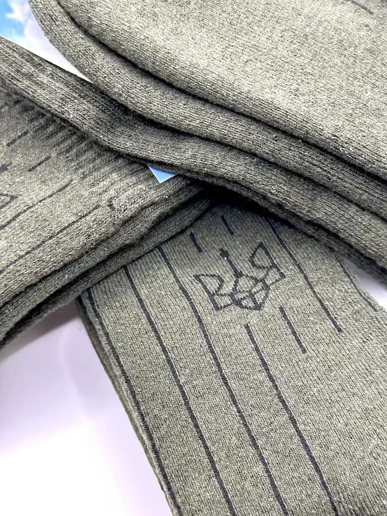 Stack of green army socks with a logo on a white background