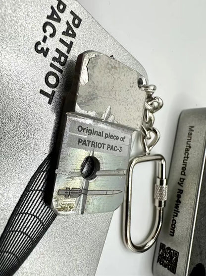 Keychain with a piece of Patriot PAC-3 on a metallic background