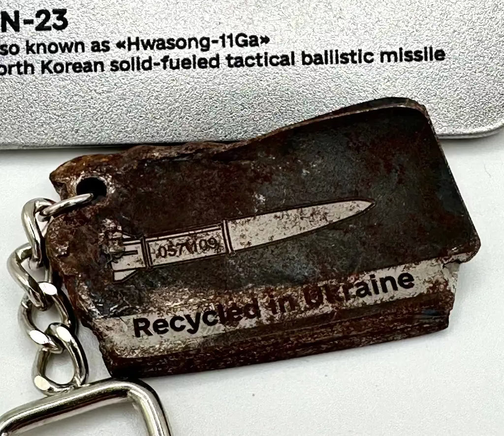 Keychain with a North Korean solid-fueled tactical ballistic missile design, labeled 'Recycled in Britain'.