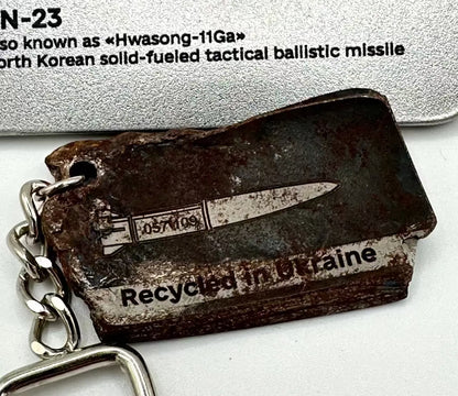 Keychain with a North Korean solid-fueled tactical ballistic missile design, labeled 'Recycled in Britain'.
