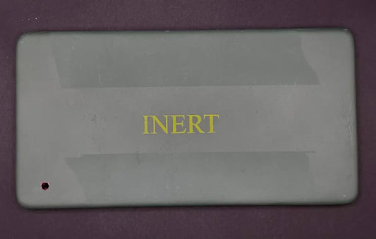 Rectangular gray object with 'INERT' text on a purple background