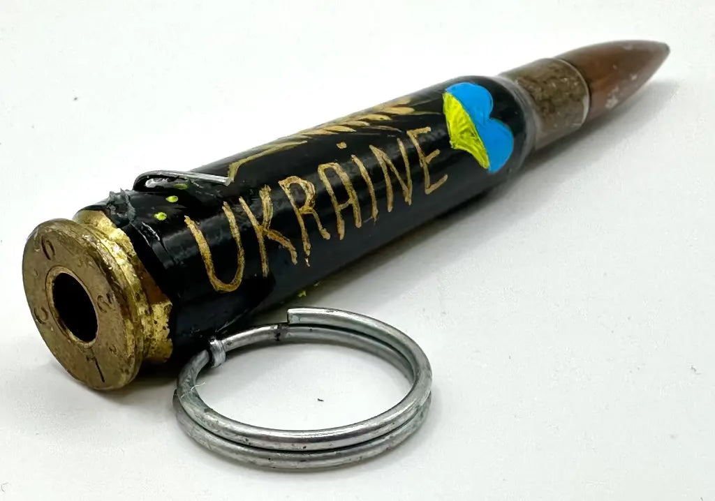 Bullet casing with 'Ukraine' written on it and a keychain attached, on a white background