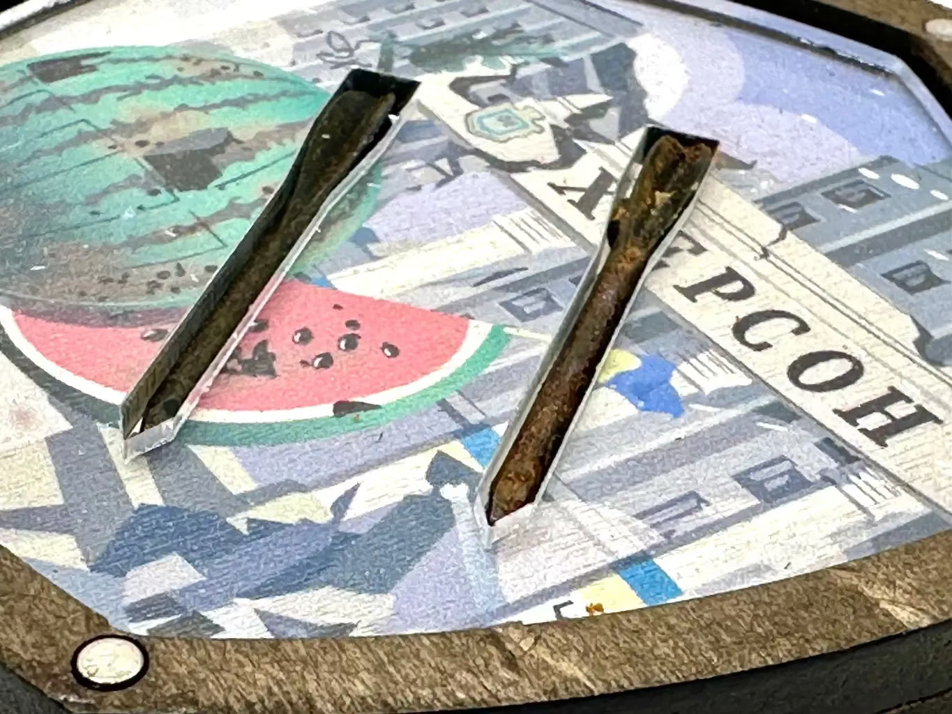 Metal tongs on a surface with a colorful abstract design