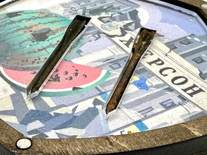 Metal tongs on a surface with a colorful abstract design