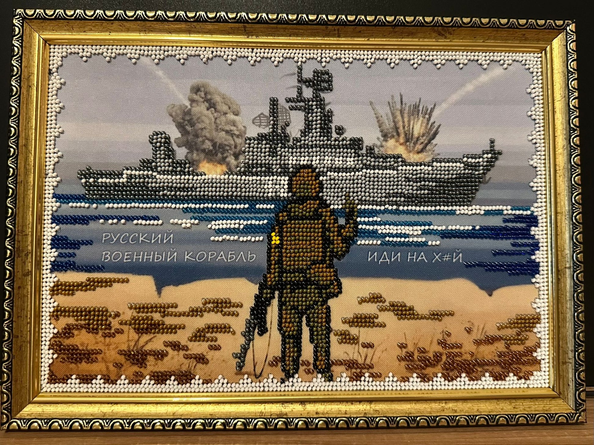 Framed Beadwork picture showing the world famous Russian Warship go f**k yourself meme soldier standing in front of a Russian warship showing him the bird