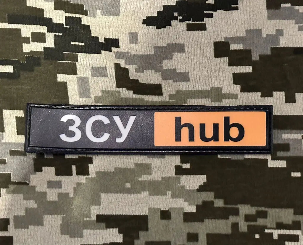 A rectangular patch with a camouflage background and the text '3CYHUB' in black with an orange border.