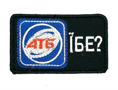 A morale patch with a blue and white design featuring text and a symbol, on a black background.