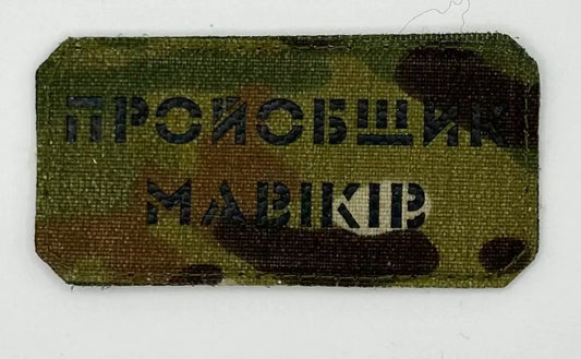 Camouflage patch with text on a white background