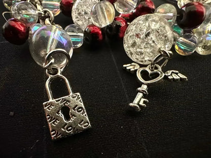 Bracelet with lock charm and heart angel wing charm on a dark background