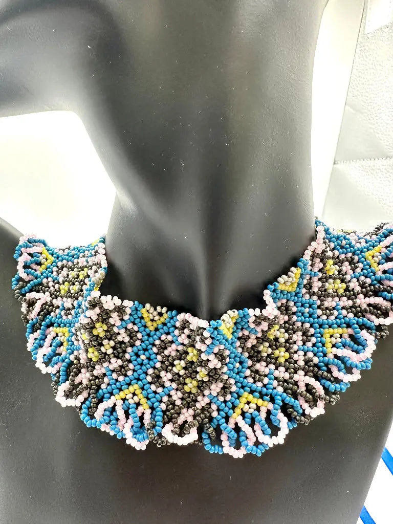 Beaded necklace on a mannequin with a black background