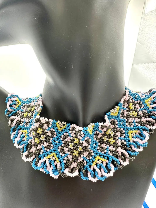 Beaded necklace on a mannequin with a black background